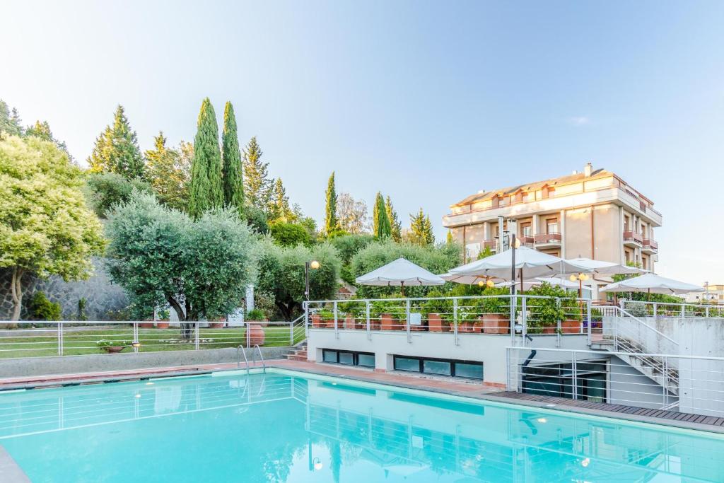 a swimming pool in front of a building at Hotel Umbria in Attigliano