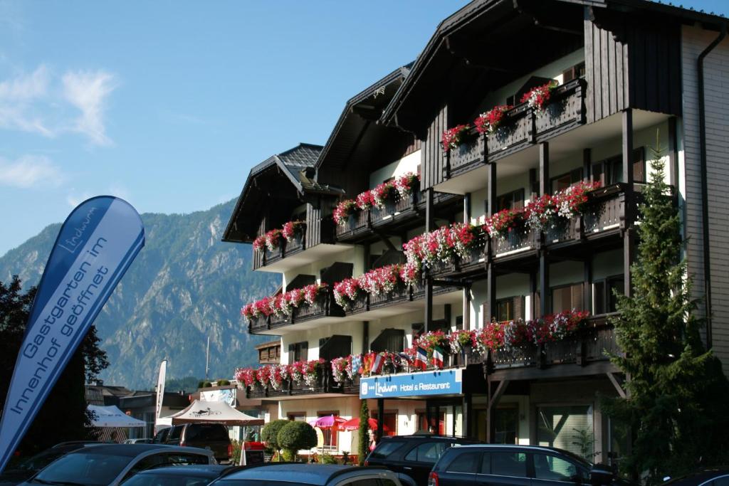 ein Gebäude mit Blumentopfen auf den Balkonen in der Unterkunft Hotel Lindwurm in Bad Goisern