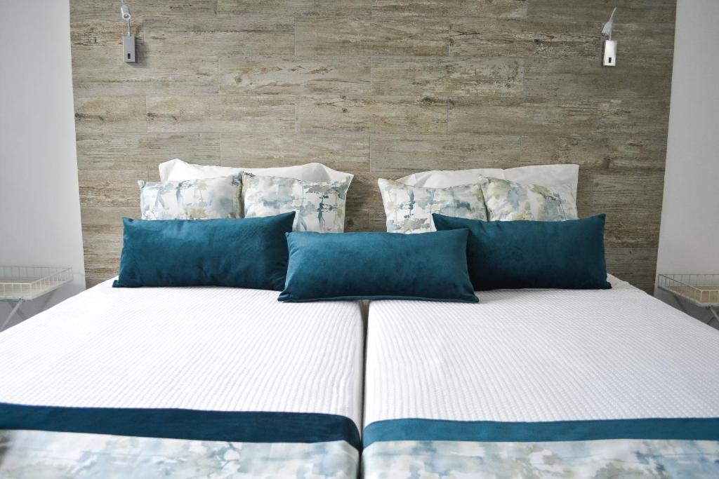uma cama grande com almofadas azuis num quarto em Belém River Apartment II em Lisboa