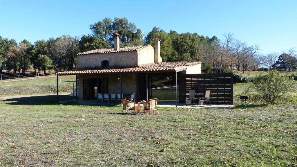 a small house with two chairs in a field at Finca El Zurrador in Fuenteheridos