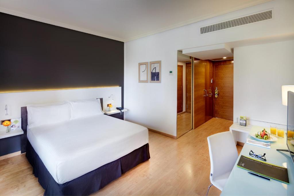 een hotelkamer met een bed en een bureau bij Sercotel Gran Hotel Zurbarán in Badajoz