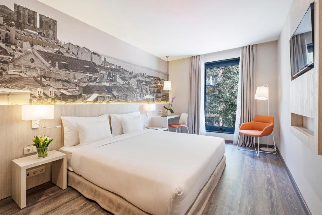 a hotel room with a large white bed and a window at EXE Liberdade in Lisbon