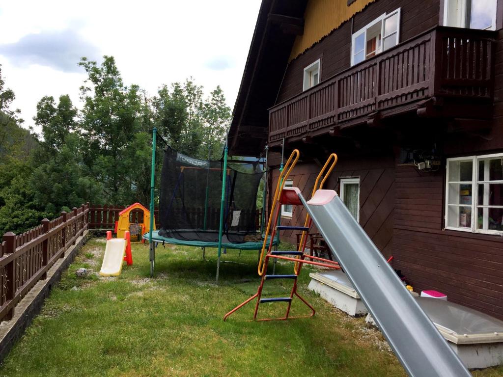 a backyard with a slide and a playground at Gasthaus Luggwirt in Gnesau