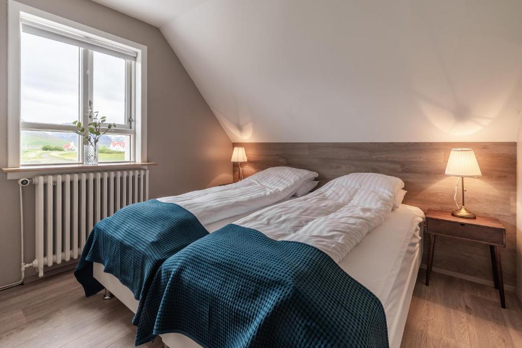 2 łóżka pojedyncze w pokoju z oknem w obiekcie Holt Inn w mieście Flateyri