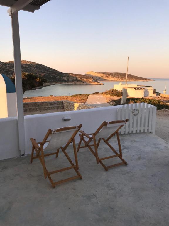Vegera Beach House, Donoussa في دونوسا: كرسيين جالسين على شرفة مطلة على المحيط