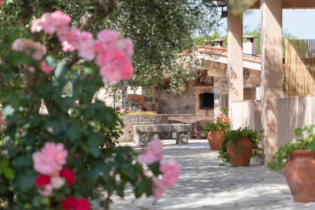 a bench in a courtyard with pink flowers at Mas le Chêne in Grimaud