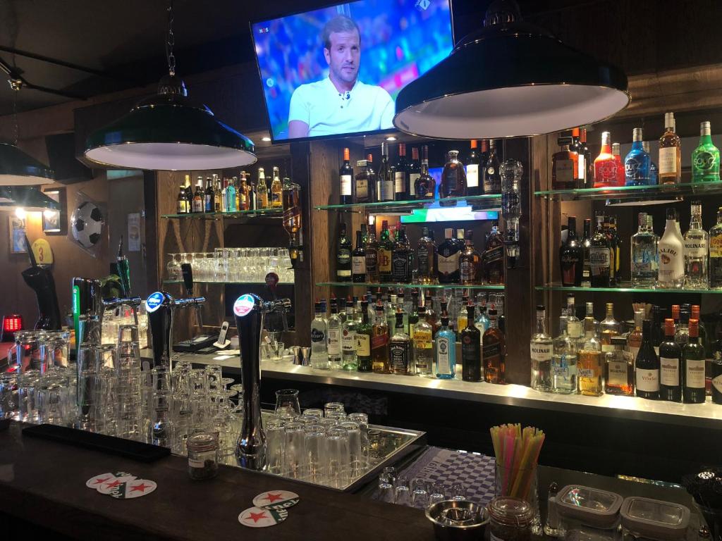 a bar with a lot of bottles of alcohol at Hotel 55 - City Centre in Amsterdam