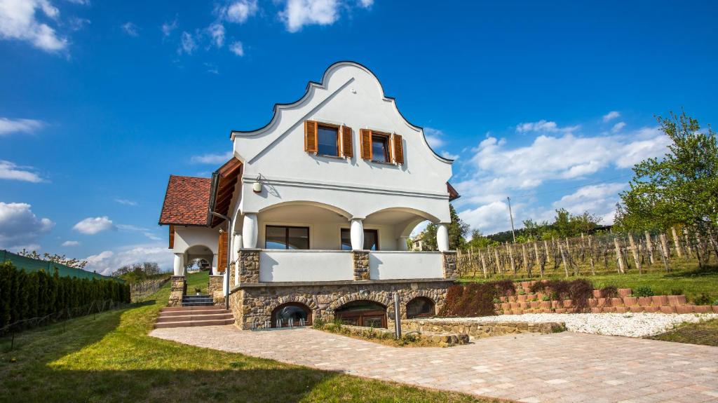 ein Haus mit einem Turm auf einem Hügel in der Unterkunft VIVAZA Villa Szigliget in Szigliget
