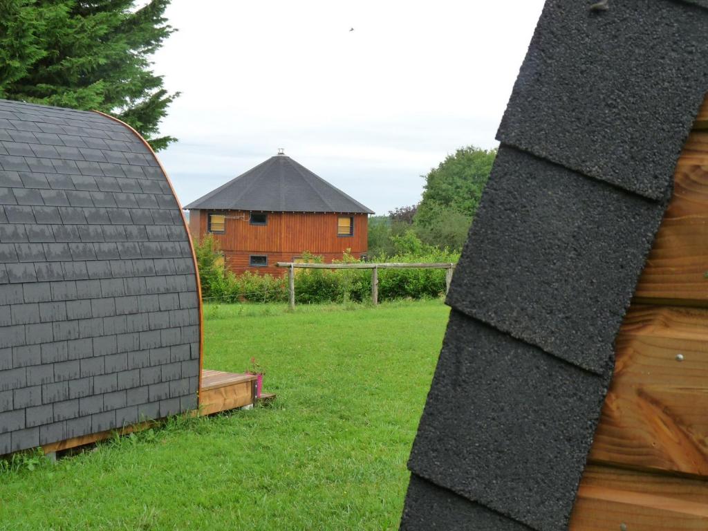 una casa en un campo con un edificio en el fondo en La maison ronde et ses 2 cahutes, en Monthoiron