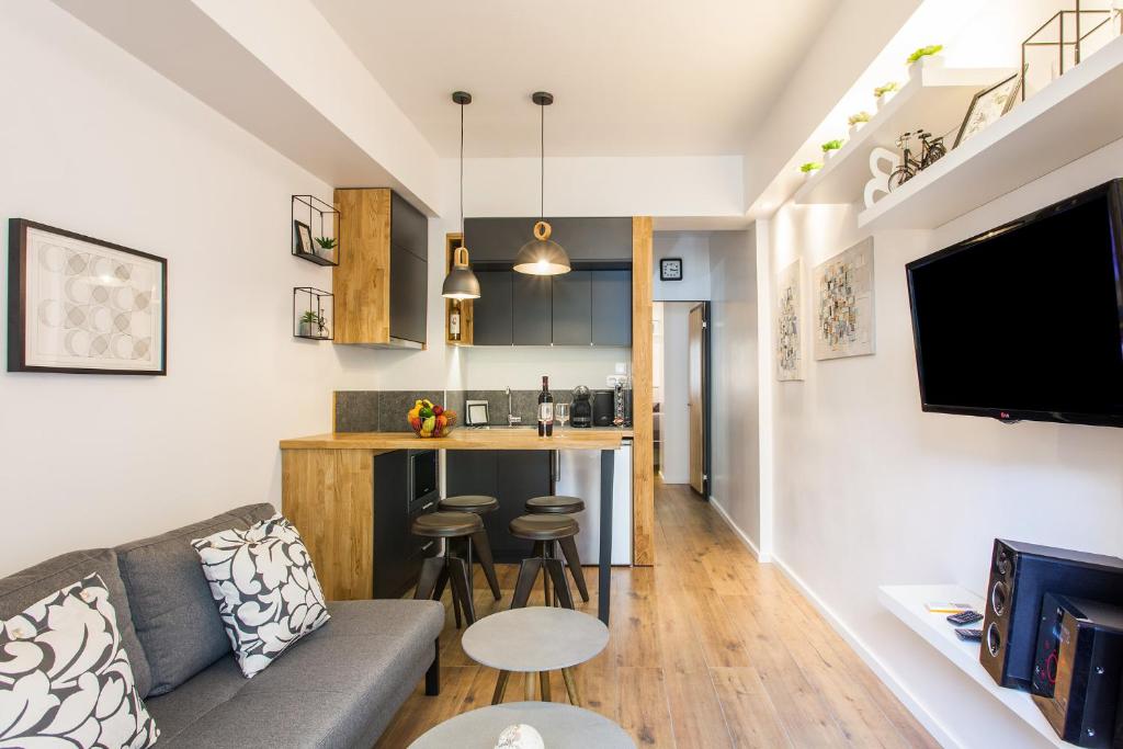ein Wohnzimmer mit einem Sofa und einer Küche in der Unterkunft Lazaristes Compact Living in Thessaloniki