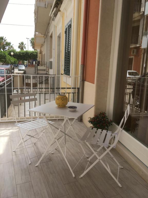 a white table and two chairs on a balcony at A Puttata ri Manu in Pozzallo