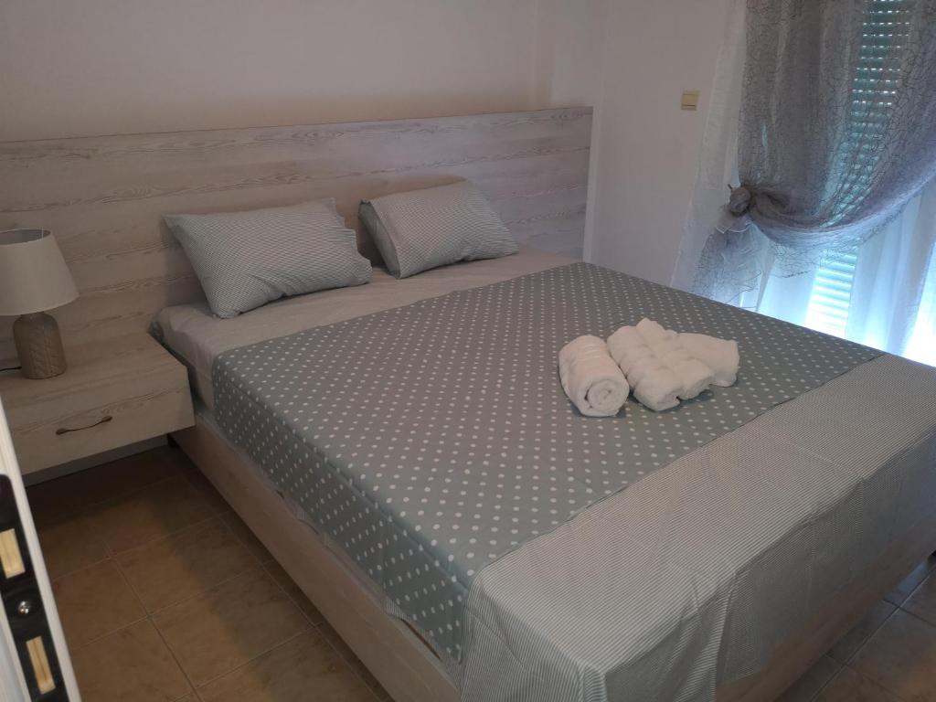 a bedroom with a bed with two towels on it at Alexandros in Aridaia