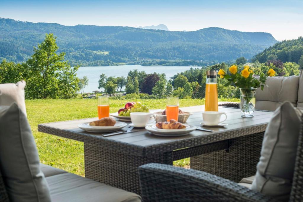 a table with food and drinks on it with a view at Lake View Apartments in Keutschach am See