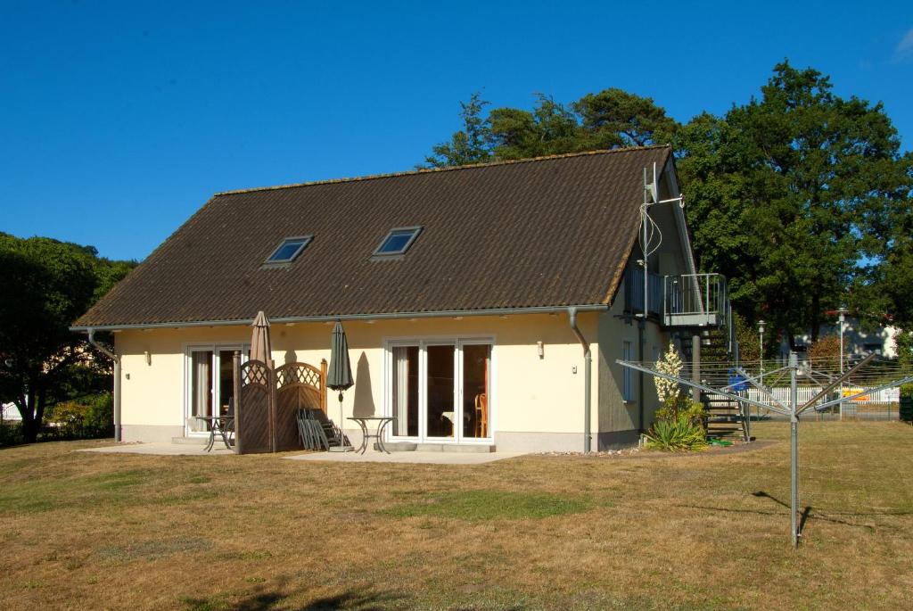 ein kleines weißes Haus mit braunem Dach in der Unterkunft Sonnenhus - Rügen in Ostseebad Sellin