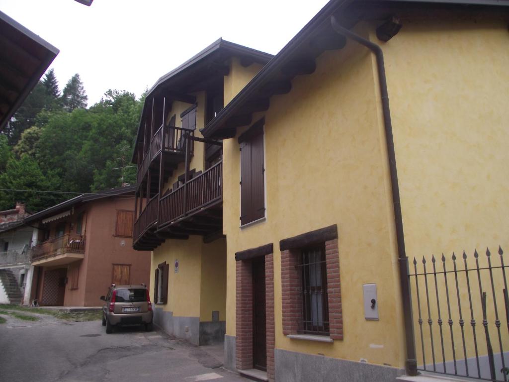 瓦爾迪耶里的住宿－La Fisarmonica，一座黄色的建筑,旁边停有一辆汽车