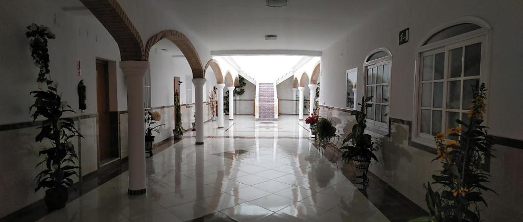 un corridoio vuoto in un edificio con finestra di Hostal Los Arcos a Chipiona