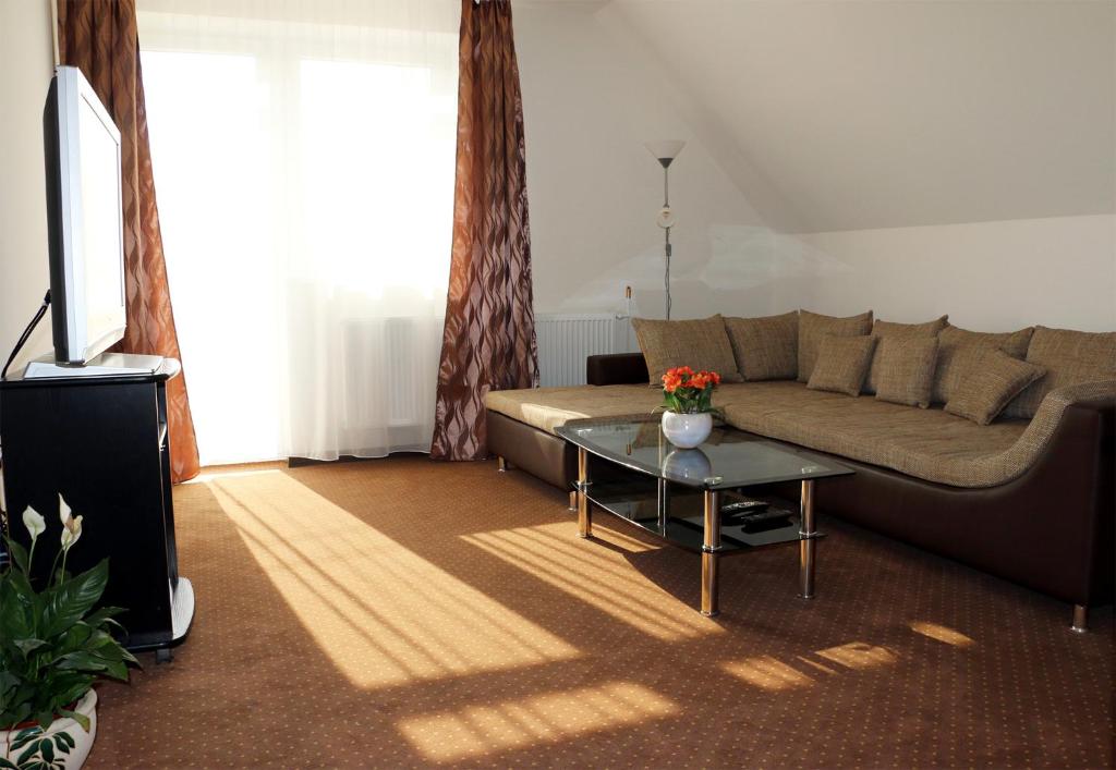 - un salon avec un canapé et une table dans l'établissement SeSil Apartman, à Pusztavám