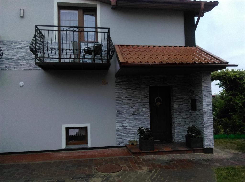 een wit huis met een balkon en een deur bij Pokoje u Jolanty in Władysławowo