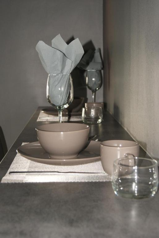 a table with two wine glasses and a plate and bowls at Appartement Studio Tournai in Tournai