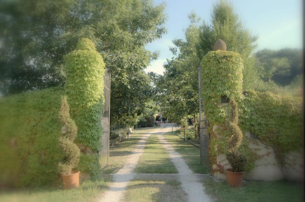 Podere Casanova في بستويا: بوابة لحديقة فيها اللبي ينمو عليها