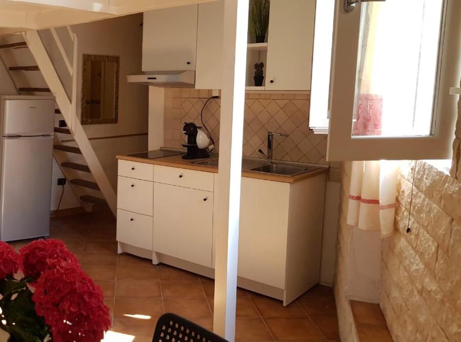 uma cozinha com armários brancos e uma escada em Mini Loft Porto Torres em Porto Torres