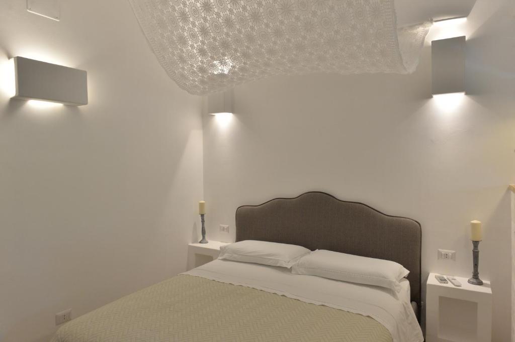 una camera da letto con un letto con due luci sul muro di Alba dei Trulli ad Alberobello