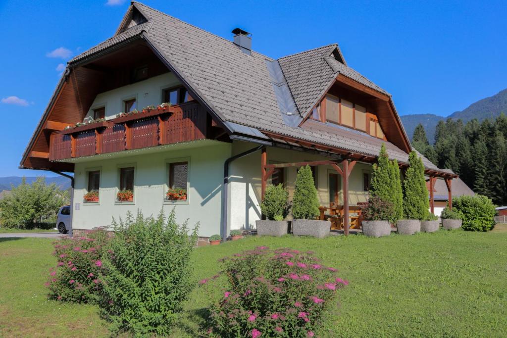 a house with a brown roof and some plants at APARTMA KOŠNIK in Bohinj