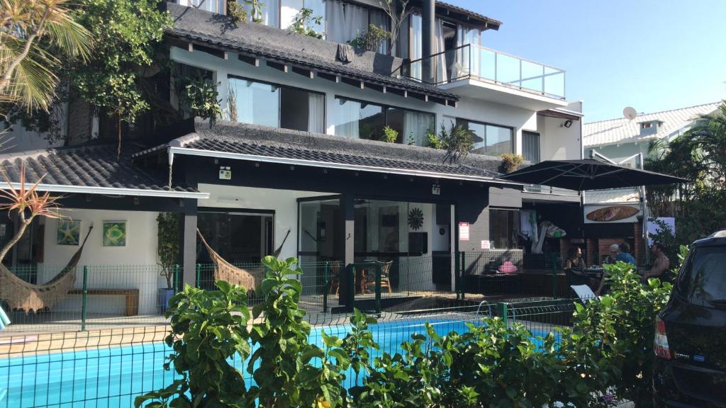 un hotel con piscina frente a un edificio en Pousada Casa da Praia en São Francisco do Sul
