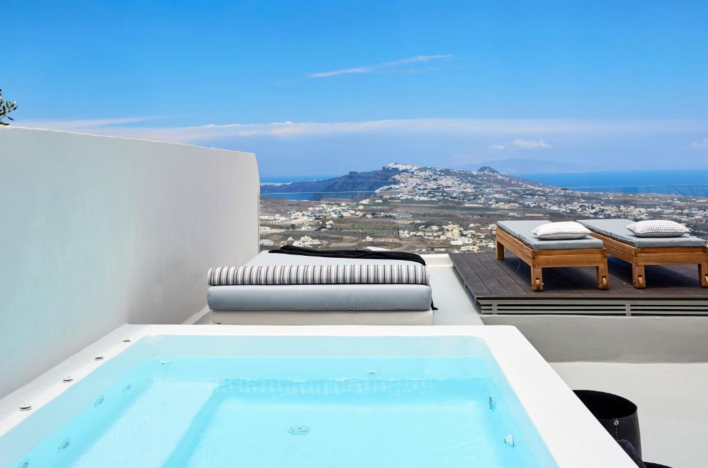 a swimming pool sitting on top of a house at White & Co. La Torre Suites in Pyrgos