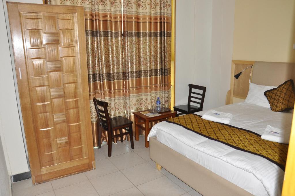 a bedroom with a bed and a table and chairs at Mekelle Hotel in Mekʼelē