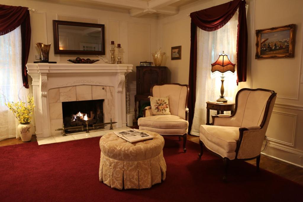 a living room with a fireplace and two chairs and a table at Martha's Vineyard B & B in South Haven