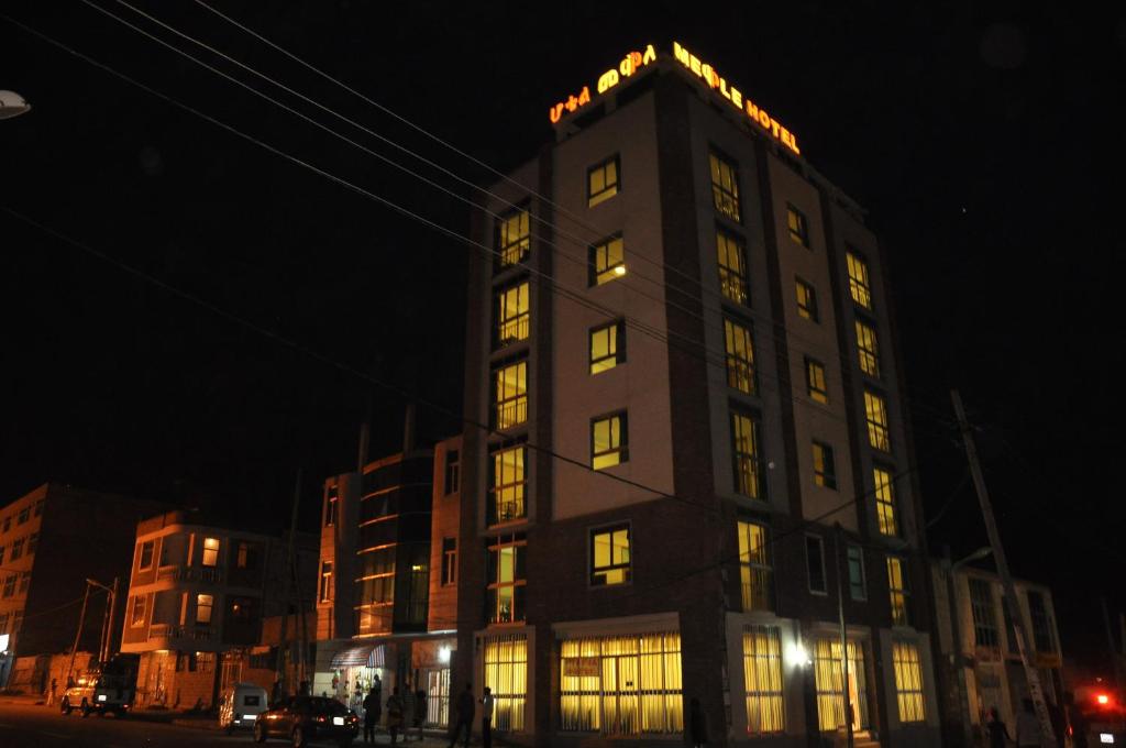 un edificio alto con finestre illuminate di notte di Mekelle Hotel a Macallè