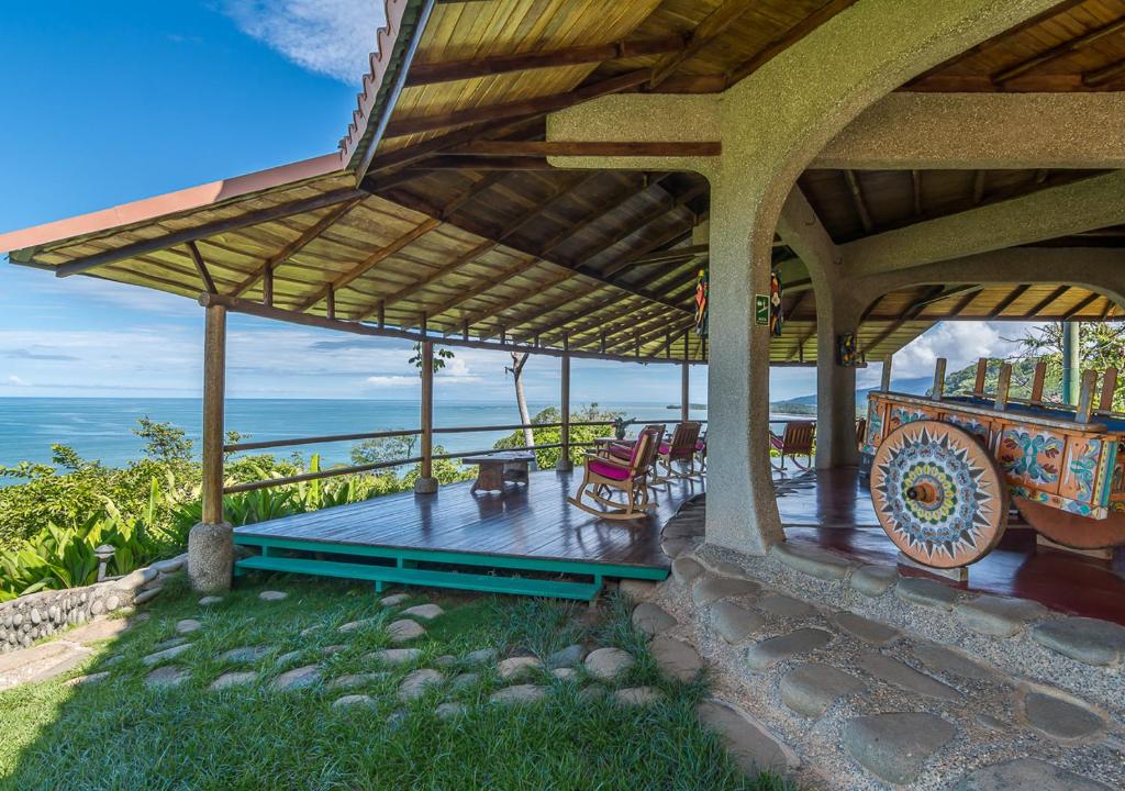 a house with a deck with a view of the ocean at La Cusinga Lodge in Uvita