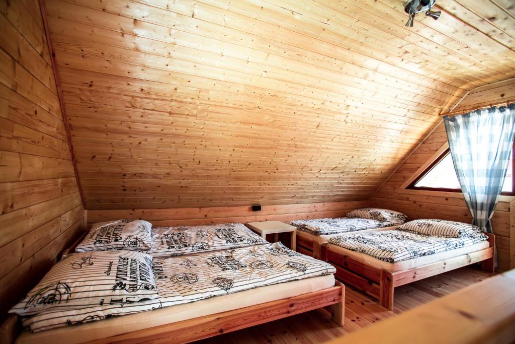 two beds in a log cabin with a window at Domki Heaven Ustronie Morskie in Ustronie Morskie