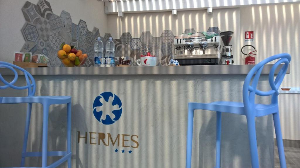 a counter with two blue chairs in a kitchen at Hermes Hotel in San Vito lo Capo