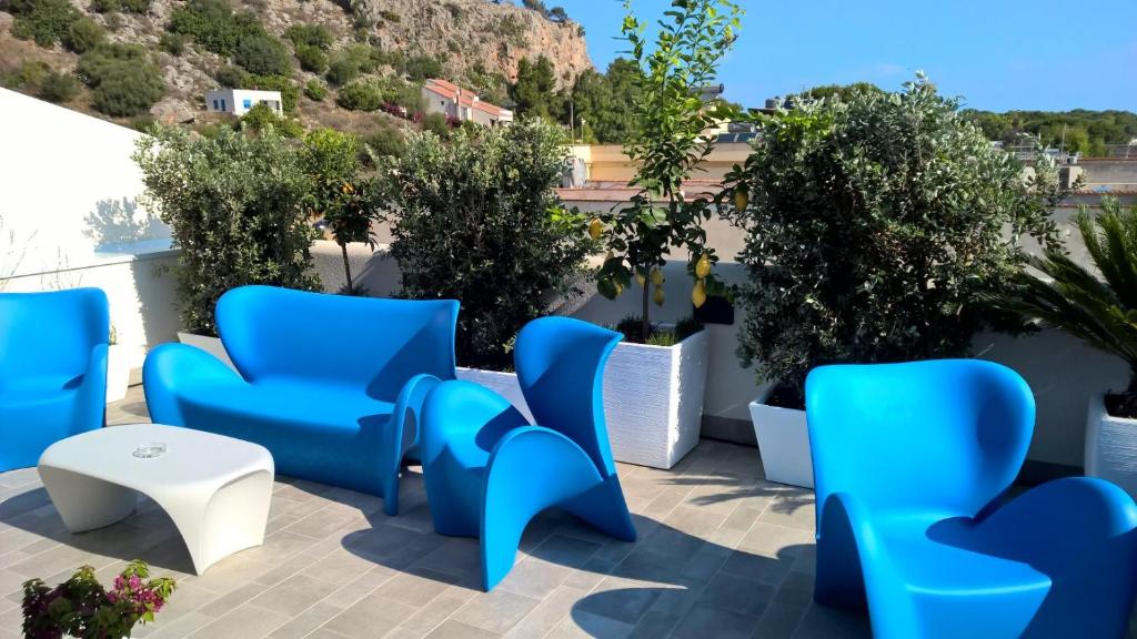 a group of blue chairs and a table on a patio at Hermes Hotel in San Vito lo Capo