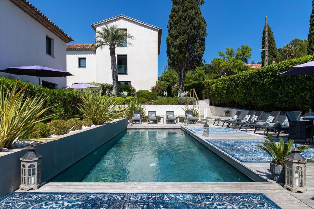 a swimming pool in the backyard of a house at Hotel le Mandala in Saint-Tropez