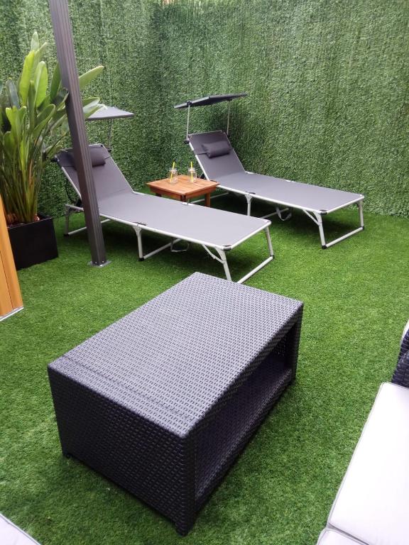 a group of chairs and tables on grass at apartment garden in Caldas de Reis