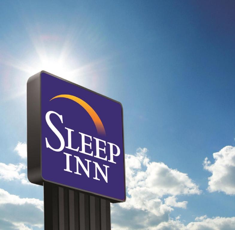 Sleep Inn & Suites Denver International Airport في دنفر: علامة لنزل للنوم أمام السماء