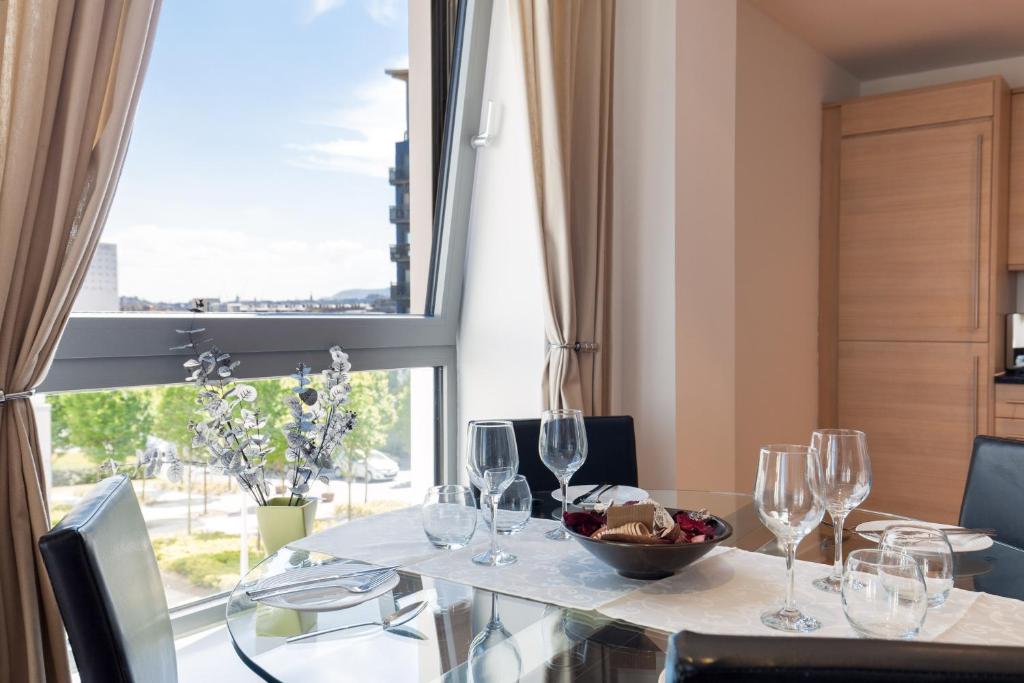 uma sala de jantar com uma mesa com copos de vinho e uma janela em Stylish Garden View Apartment em Edimburgo