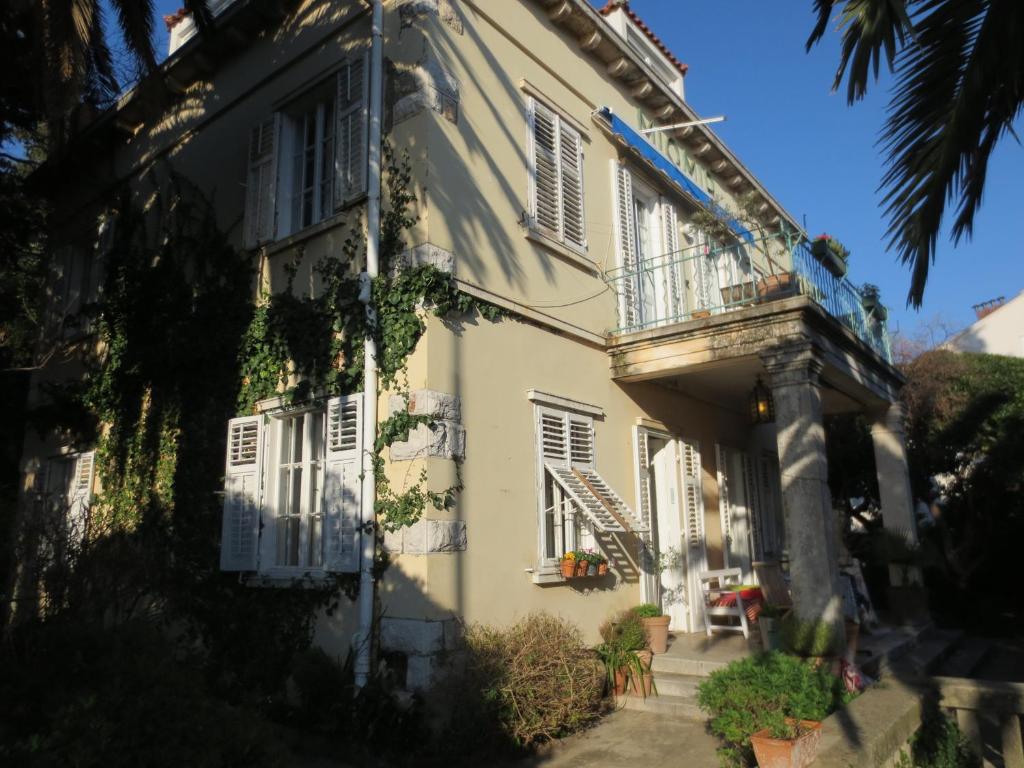 Edificio blanco con balcón y escalera en Villa Miomir, en Dubrovnik