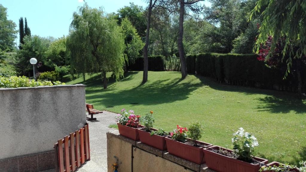 un jardin avec un banc et des fleurs dans un parc dans l'établissement La terraza del Sauce, à Jaca