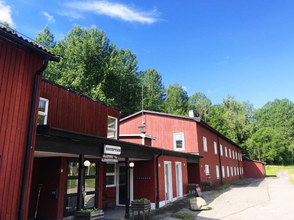 een rij rode gebouwen met bomen op de achtergrond bij Klackbergsgården in Norberg