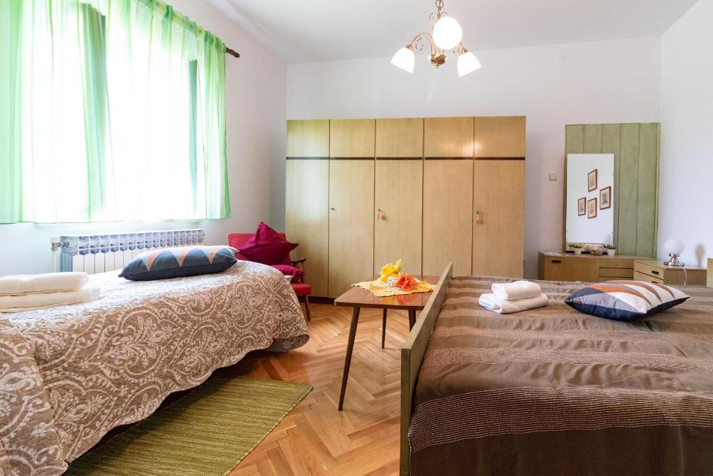 sypialnia z 2 łóżkami i stołem w obiekcie Apartments Bogetic w mieście Premantura