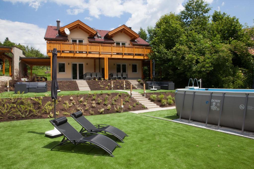 a house with a yard with chairs and a pool at Ferienhäuser Glück Auf, Sauna, Hottubs in Arnoldstein