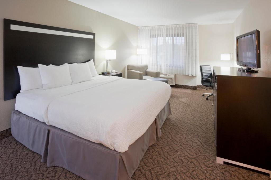 ein Hotelzimmer mit einem großen Bett und einem TV in der Unterkunft Carrollton Hotel in Carroll