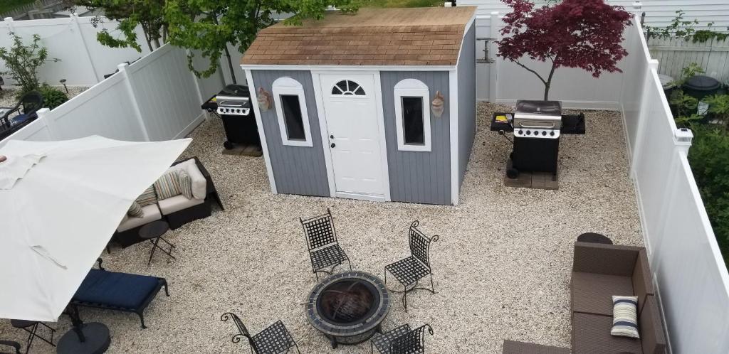 a small backyard with a dog house and chairs at 1st floor cottage! One Block to Beach, Convention Center and Wildwood Crest! in Wildwood