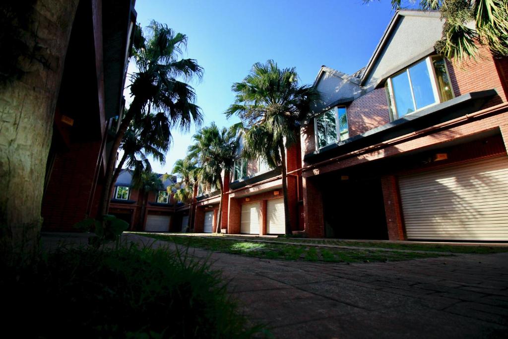 a building with palm trees in front of it at Spring City Motel in Xinfeng