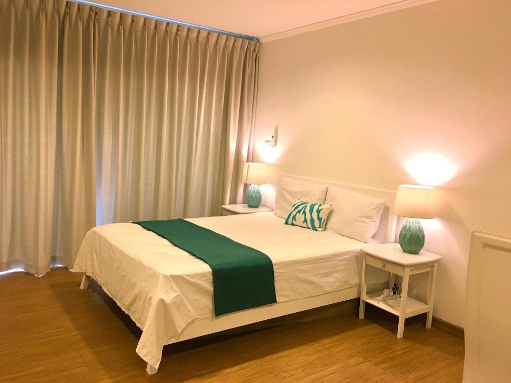 sypialnia z dużym łóżkiem i zielonym kocem w obiekcie Baan Klang Condo Hotel Hua Hin w mieście Hua Hin