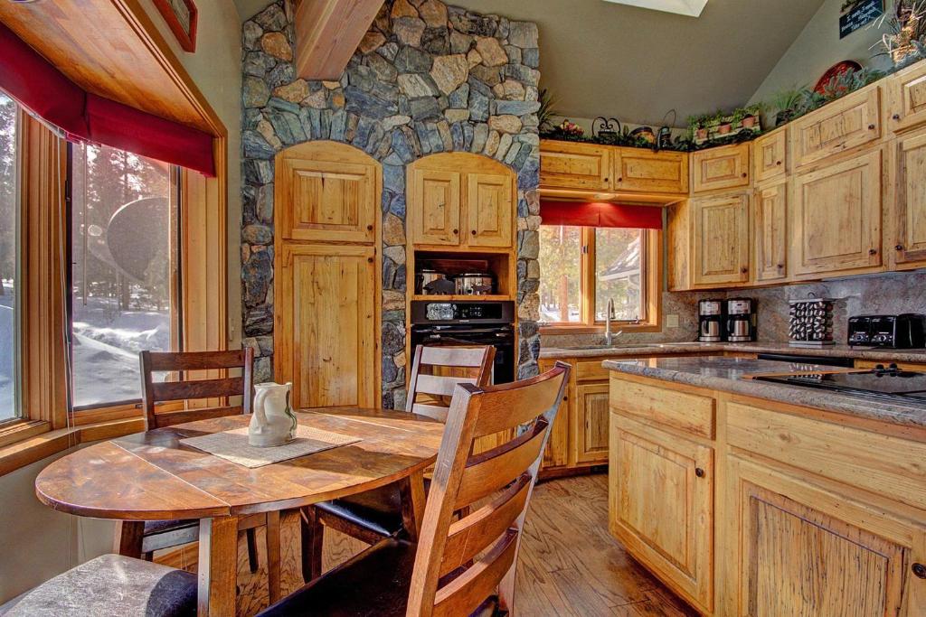 cocina con mesa y pared de piedra en Gold King Lodge Home, en Breckenridge